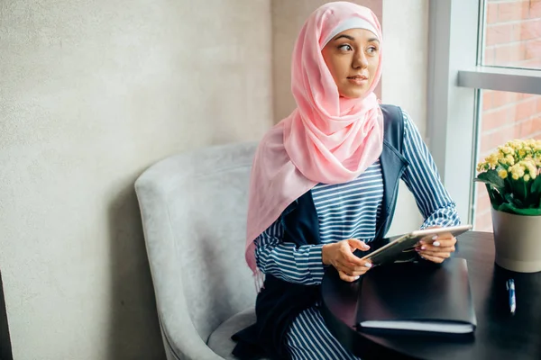 Female Muslim college student using tablet computer in cafe — Stock Photo, Image