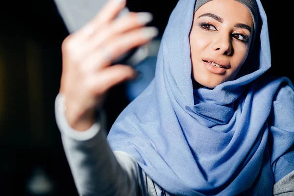 Arabian muslimska kvinnan tar selfie med telefon i café — Stockfoto