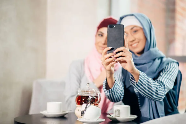 Joven hermosa mujer musulmana tomando un autorretrato con teléfono de la cámara — Foto de Stock