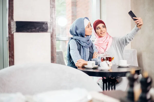 Две мусульманки-подруги селфи на смартфоне — стоковое фото