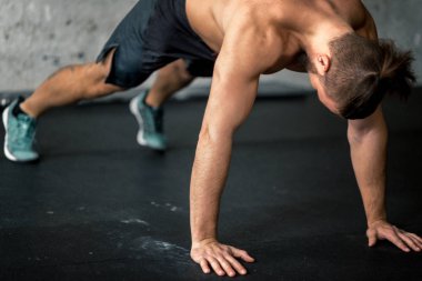 Spor salonunda push-up yapıyor genç yakışıklı adam yan görünüm