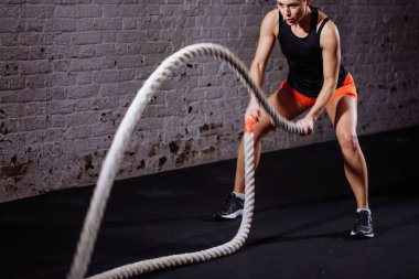 Kadın yapmak egzersiz fonksiyonel eğitim salonunda savaş iple