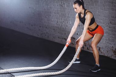 Kadın yapmak egzersiz fonksiyonel eğitim salonunda savaş iple