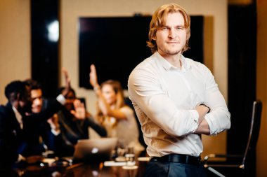 işadamı kameraya bulanık işçilerle arka plan üzerinde seyir.