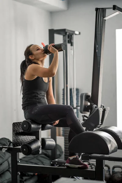 Fille boire de l'eau dans la salle de gym après l'entraînement — Photo