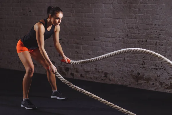 Athletic woman doing battle rope exercises at gym — Stock Photo, Image