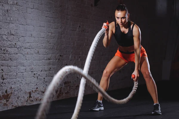 Slag touwen sessie. Aantrekkelijke jonge fit en afgezwakte sportvrouw training in de sportschool — Stockfoto