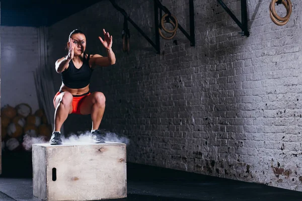 Femme sautant boîte. Fitness femme faisant boîte saut séance d'entraînement à la gym cross fit . — Photo
