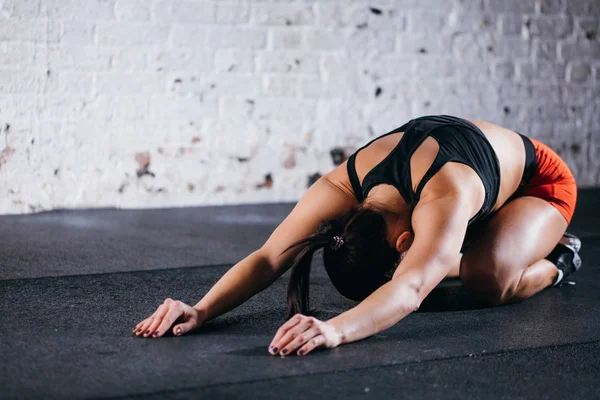 Mujer estirándose hacia atrás o descansando acostada después de un entrenamiento pesado en el gimnasio — Foto de Stock