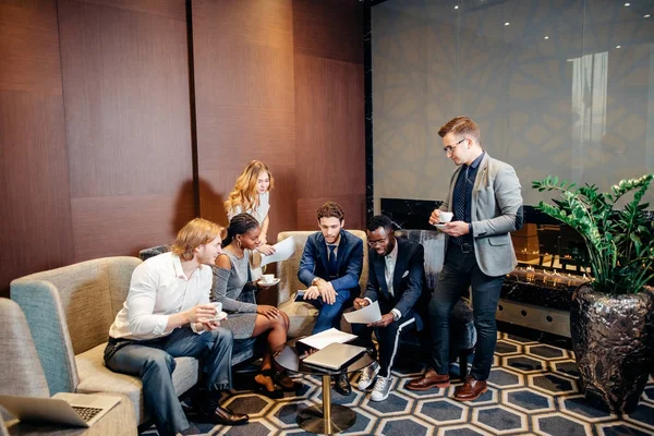 Equipe de empresários africanos e caucasianos reunidos no escritório — Fotografia de Stock