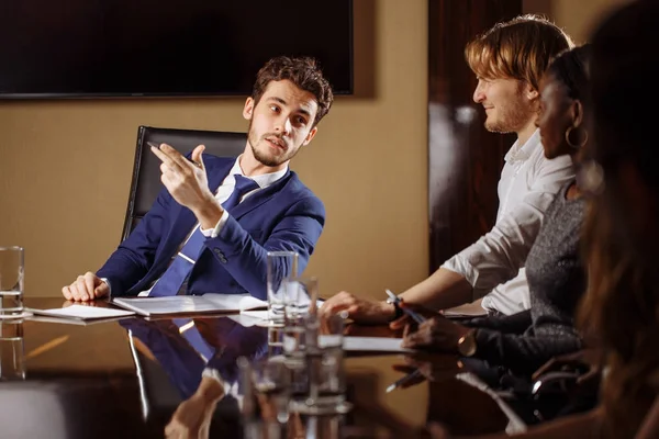 Team leader talking with coworkers in modern office