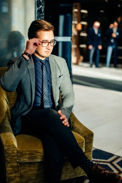 O homem está a preparar-se para a entrevista. Ele de terno, sentado no corredor na cadeira, esperando — Fotografia de Stock