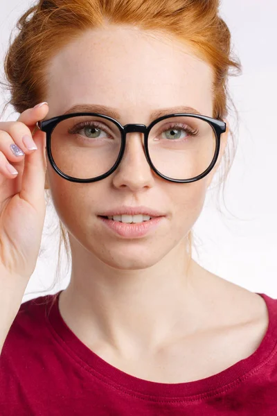 Rothaarige lächelnde Frau in rotem Hemd mit Brille auf weißem Hintergrund — Stockfoto