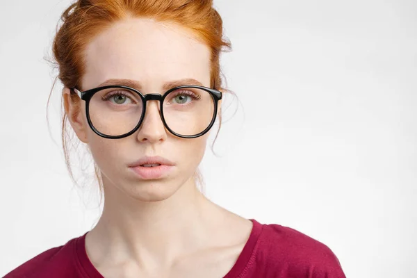 Рыжая женщина в очках с узлом на белом фоне — стоковое фото