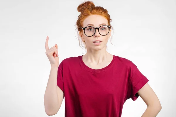 Rossa femminile che punta verso lo spazio di copia, guardando la fotocamera — Foto Stock