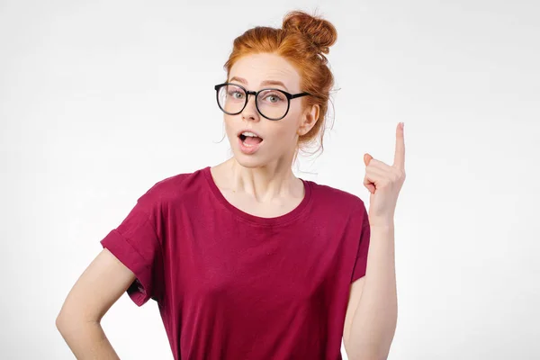 Chica sorprendida mostrando espacio de copia con el dedo fondo blanco. chica apuntando hacia arriba — Foto de Stock