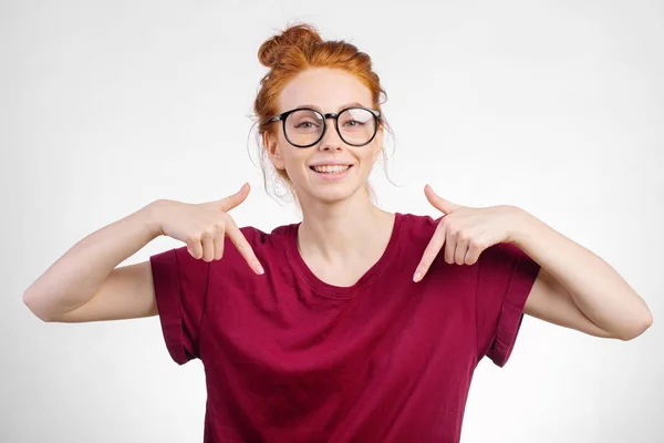 Linda pelirroja chica apuntando hacia abajo en copyspace —  Fotos de Stock