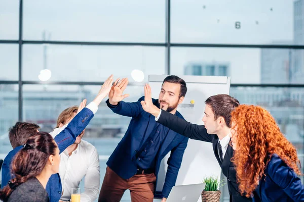 Equipe de negócios está dando alta cinco e sorrindo enquanto está no escritório — Fotografia de Stock