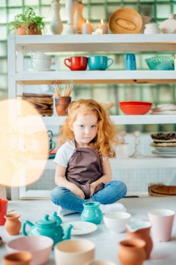 Kızıl saçlı kız lotus poz Studio oturan seramik bardak yapılır