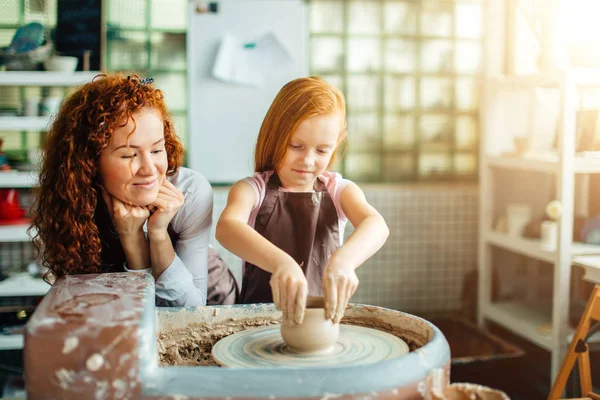 Roodharige zusjes maken een werper voor een aardewerk wiel — Stockfoto