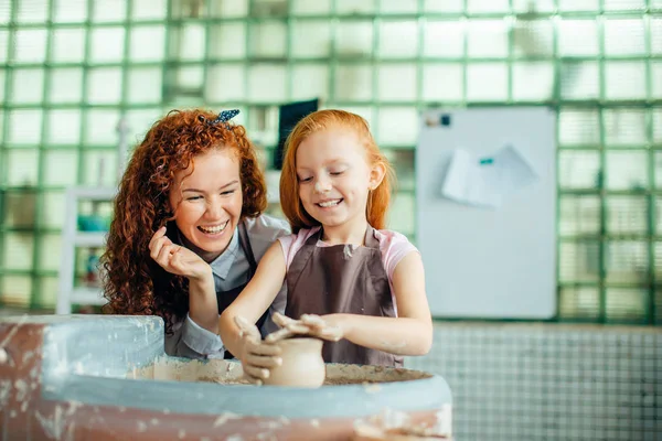 Rossa madre e suo figlio figlia stampaggio con argilla su ceramica ruota — Foto Stock