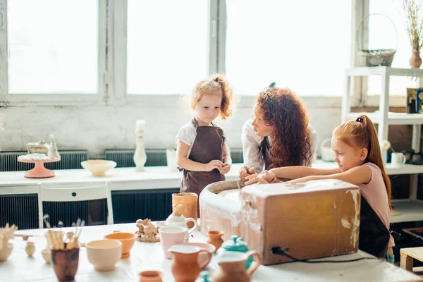 母と 2 人の赤毛の娘作った陶芸粘土カップ — ストック写真