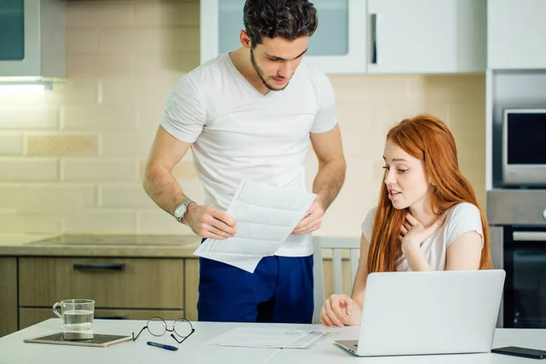 Couple discussing about domestic bills at home while looking at documents — Stock Photo, Image