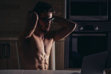 Genç fiziksel olarak uygun adam poz ve Laptop istimal