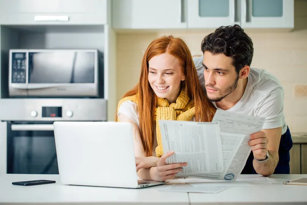 快乐的年轻夫妇计算他们的账单在家里 — 图库照片