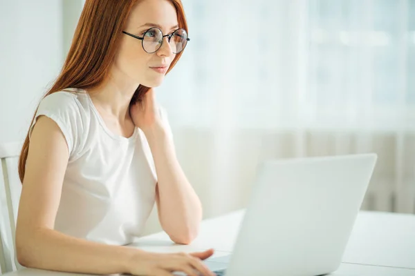 Pelirroja usando computadora portátil. Mujer trabajando en el ordenador portátil —  Fotos de Stock