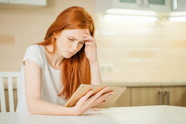 Female entrepreneur thinking while working at table in her kitchen at home — Stock Photo, Image