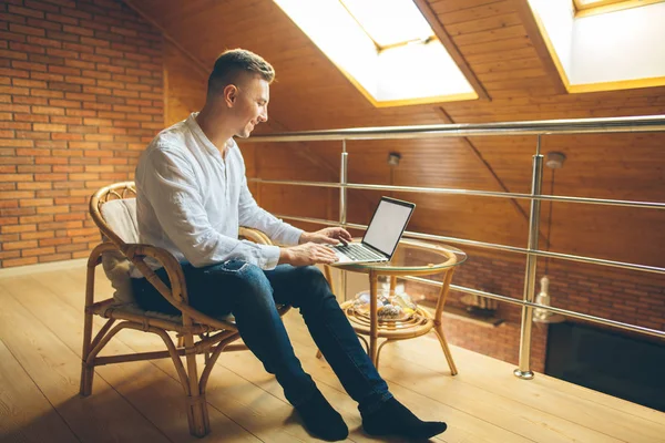 Man om thuis te zitten en die op laptop werkt. man werken vanuit loft kantoor aan huis — Stockfoto