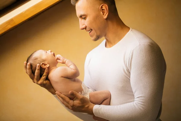 父亲抱着新生婴儿靠近窗户 — 图库照片