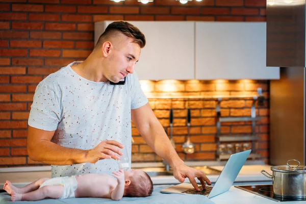 Homem trabalhando em casa e cuidando do bebê — Fotografia de Stock