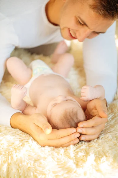 Padre sdraiato sul letto e tiene il suo bambino — Foto Stock