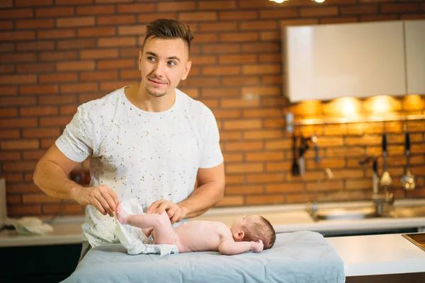 father is changing nappy to his baby boy