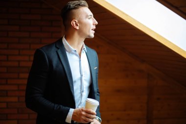 Evde kahve içme ve uzak seyir yakışıklı işadamı