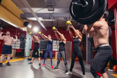 Güzel sporcular kettlebell salıncaklar yapıyor.