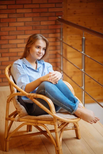 Wanita muda bersantai di kursi besar yang nyaman — Stok Foto