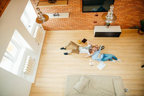 Pareja estudiando mientras está acostado en el suelo en casa — Foto de Stock