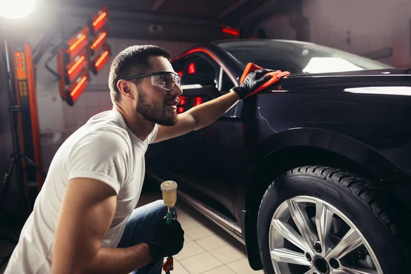 Détail de la voiture - l'homme tient la microfibre à la main et polit la voiture — Photo