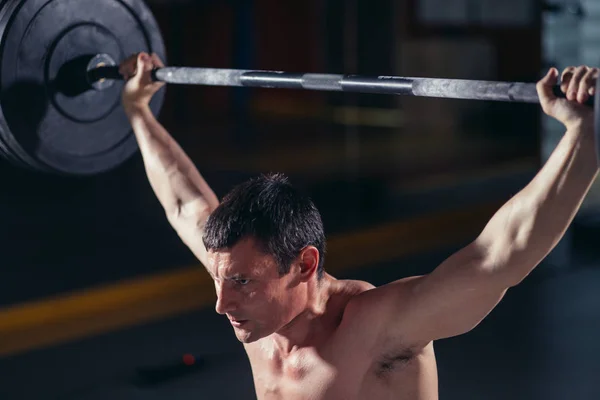 Fitness homme soulevant haltère lourd à la salle de gym — Photo