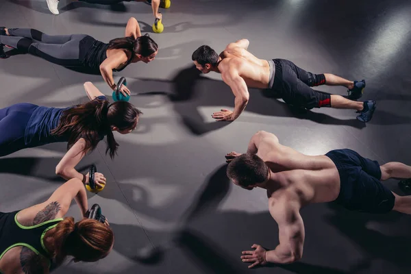 Groupe d'adultes faisant des exercices push up à l'intérieur — Photo