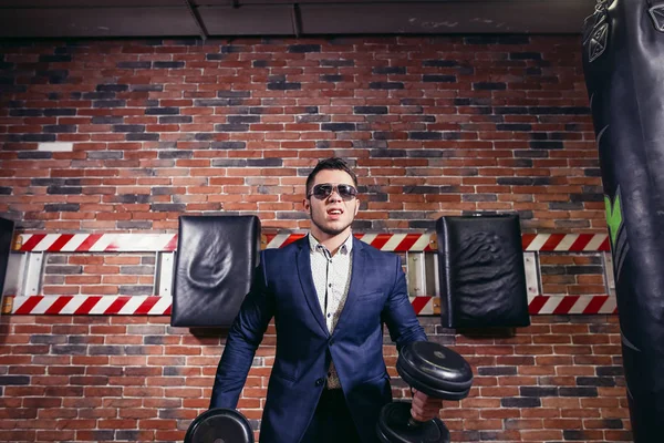 Man in pak tillen gewicht in sportschool — Stockfoto