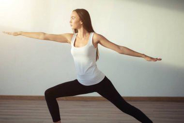 pratik yoga, savaşçı bir egzersiz, Virabhadrasana duran kadın