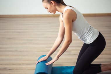 pratik yoga, uygulamada, unrolling veya çalışırken yoga mat hazırlama kadın