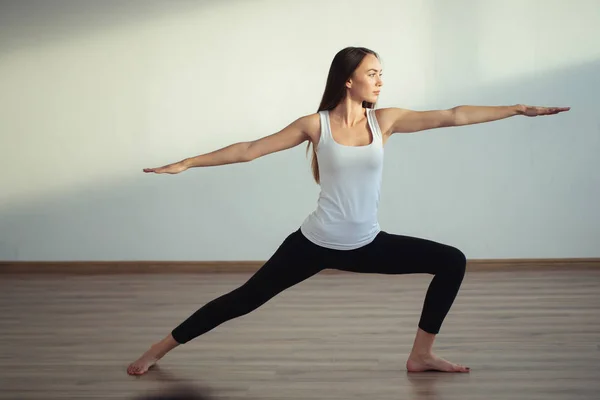 Mulher praticando ioga, de pé em Guerreiro um exercício, Virabhadrasana — Fotografia de Stock