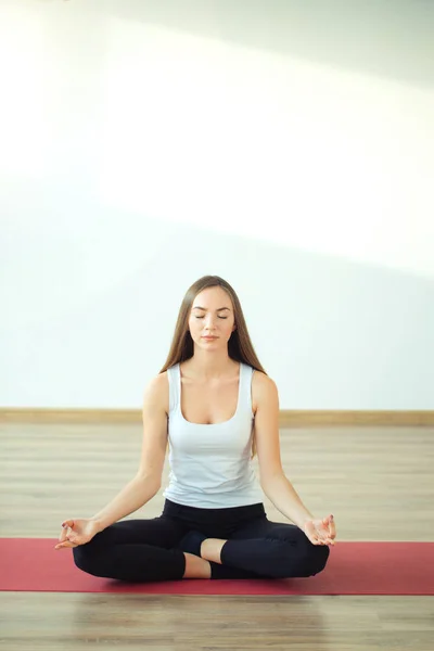 Mujer joven medita mientras practica yoga — Foto de Stock