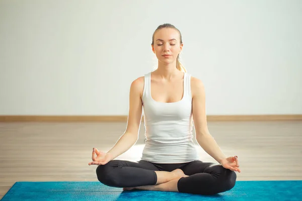 Młoda kobieta medytuje podczas uprawiania jogi — Zdjęcie stockowe