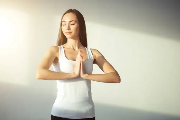 Kvinna praktisera yoga och meditation, hålla handflatorna tillsammans i namaste mudra — Stockfoto